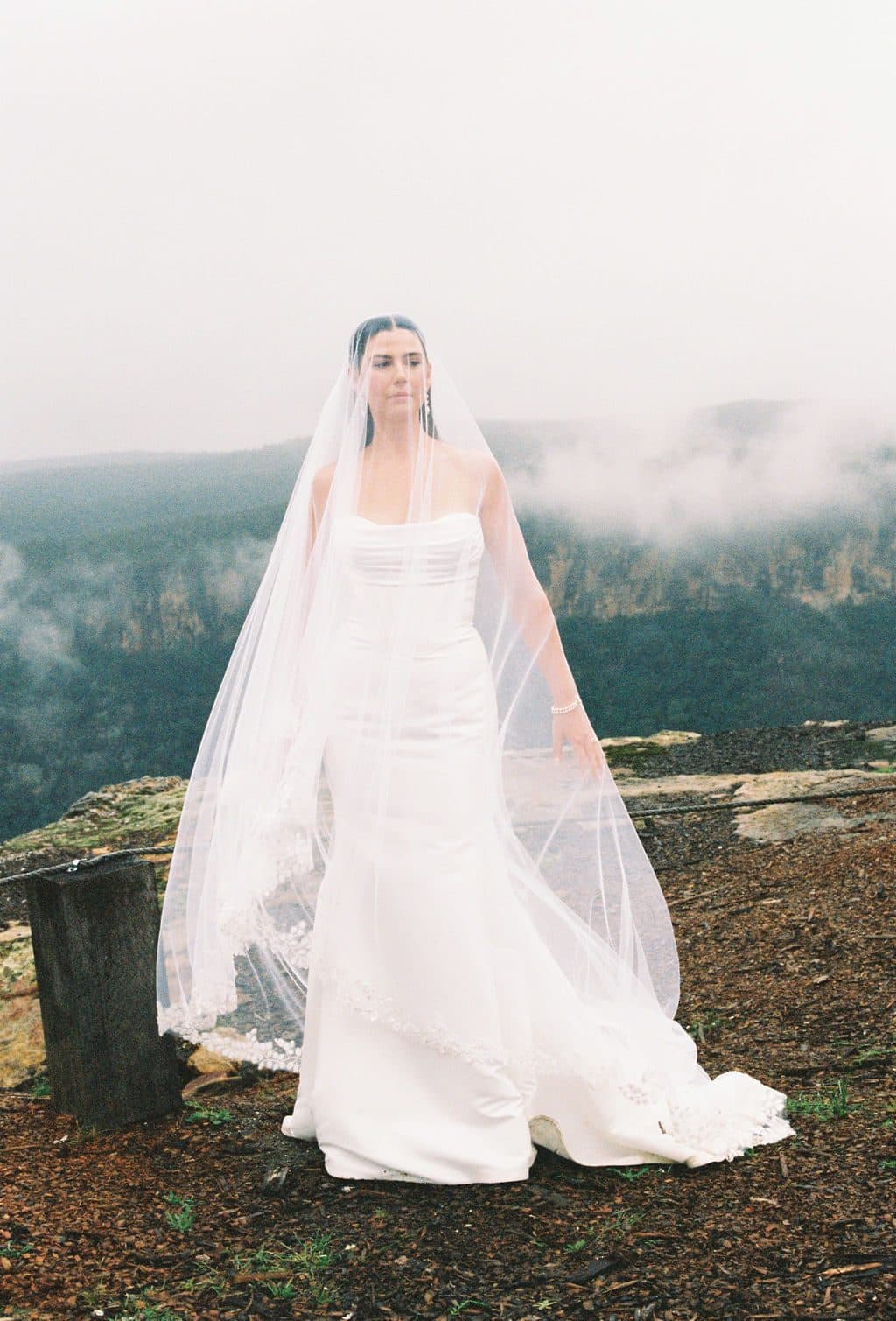 The bride on the misty edge of the cliff, veil drifting into the gorge