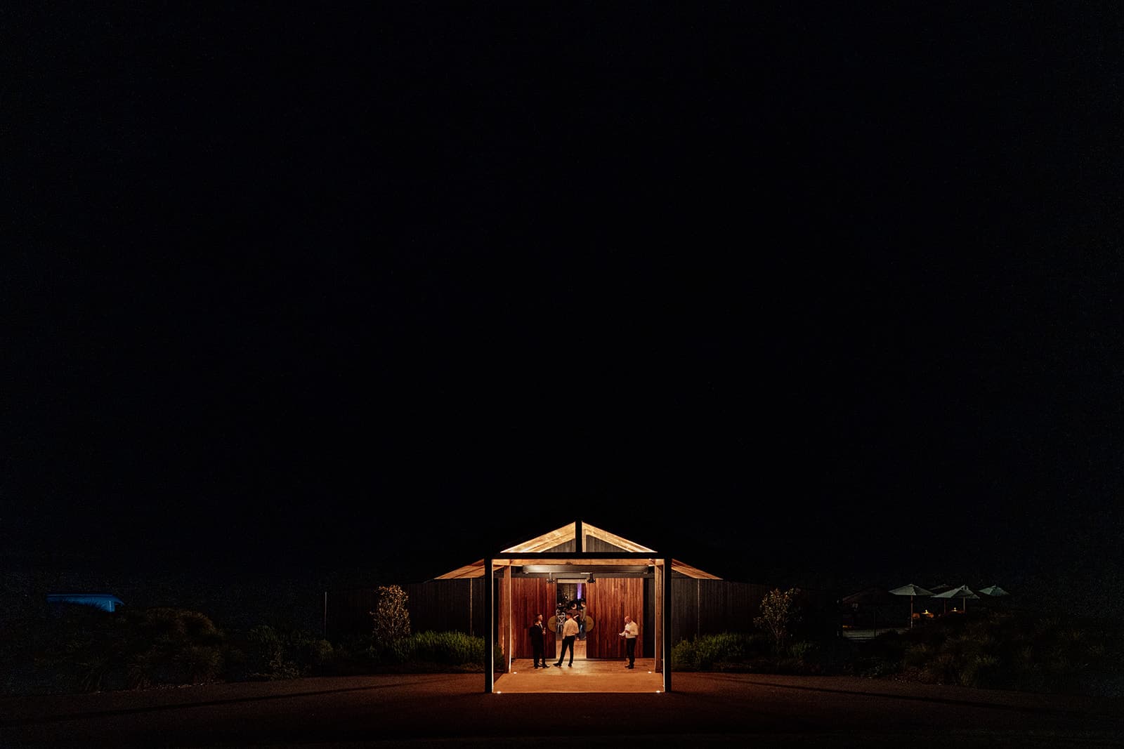 The Pavilion's floor-to-ceiling glass glowing warm against the night